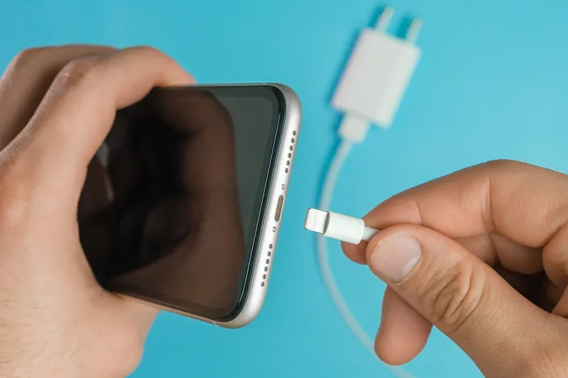 A close-up of a phone charging port being repaired
