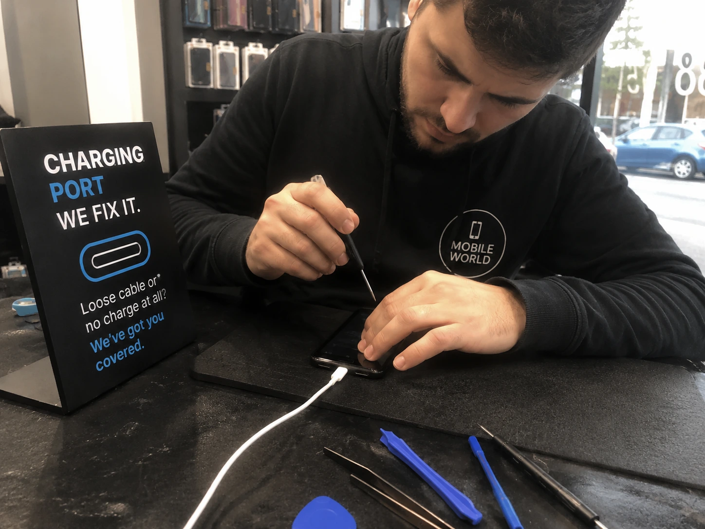 A close-up of a phone charging port being repaired